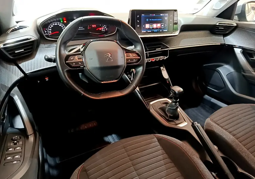 Intérieur de la Peugeot 2008 essence 2020, vue avant centrée sur le volant cuir et l'écran tactile du tableau de bord.