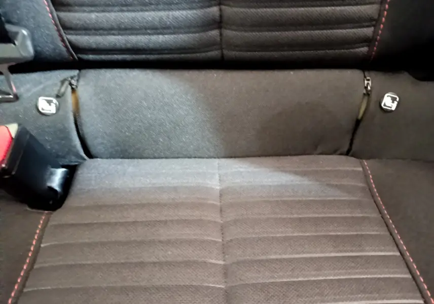 Gros plan sur la banquette arrière noire avec surpiqûres rouges et fixations Isofix du Peugeot 2008.