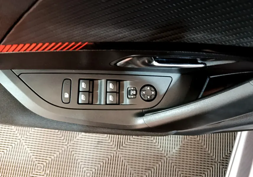 Panneau de porte côté gauche du Peugeot 2008 gris clair, avec commandes des vitres et rétroviseurs électriques.