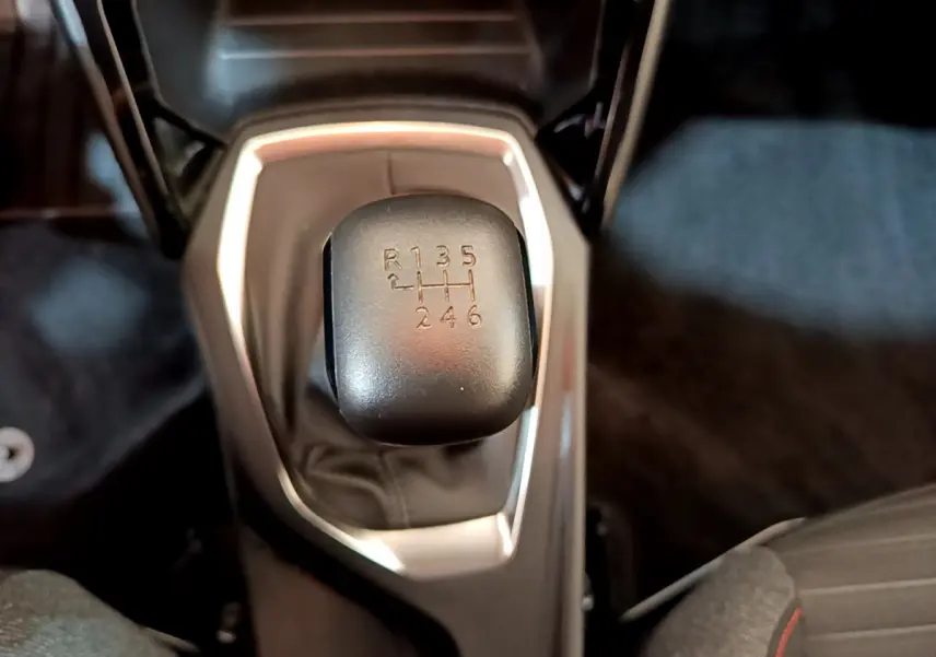 Le levier de vitesses manuel noir vu de dessus dans l'habitacle du Peugeot 2008 gris clair 2020.