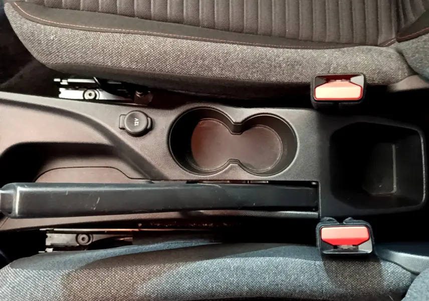 Vue plongeante sur la console centrale noire avec frein à main, porte-gobelets et sièges tissu gris du Peugeot 2008 2020.