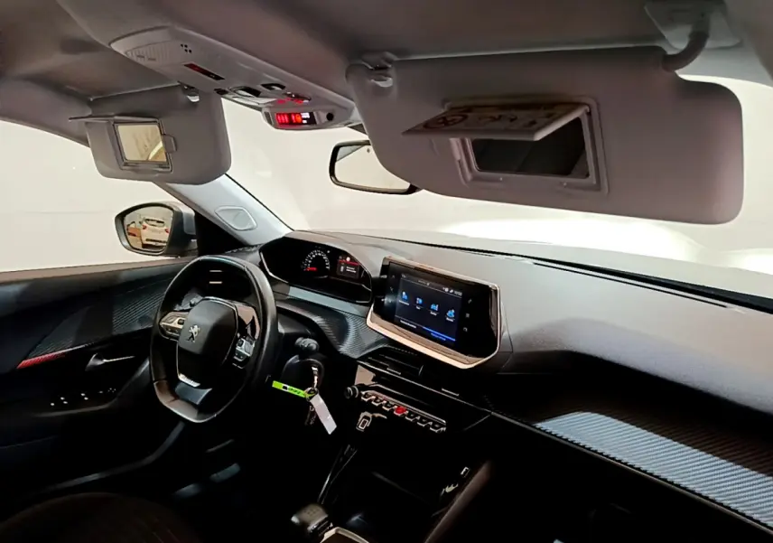 Vue intérieure côté conducteur du Peugeot 2008 2020, tableau de bord noir avec écran tactile et volant cuir multifonctions.