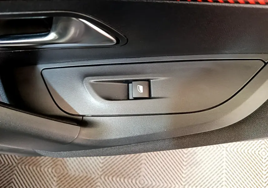 Bouton de commande de lève-vitre sur la porte intérieure côté conducteur d'une Peugeot 2008 gris clair de 2020.