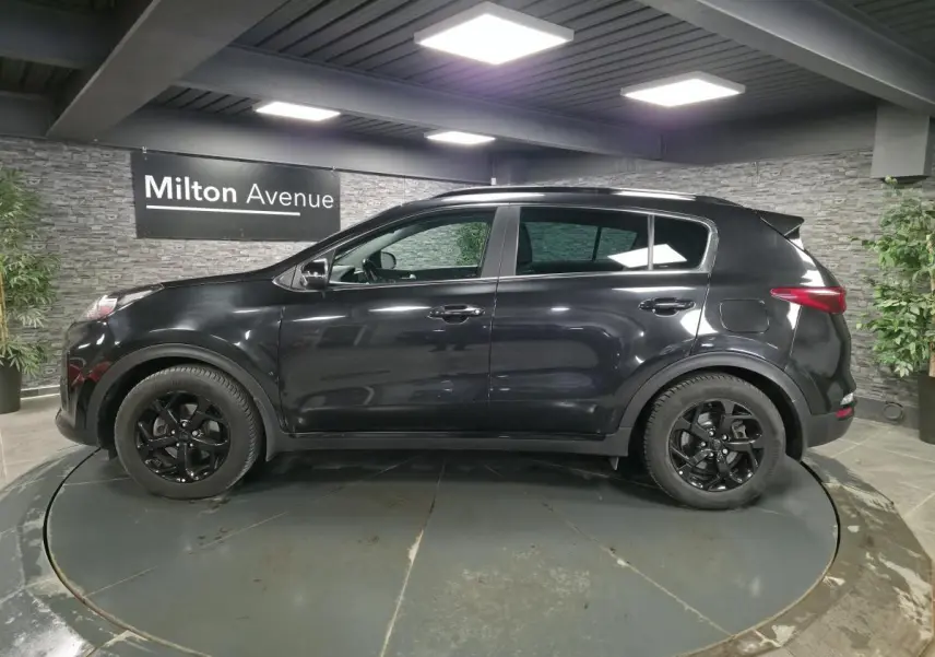 Vue de profil côté gauche d'un KIA Sportage noir Black Edition 2021 avec jantes alliage noires et toit panoramique.