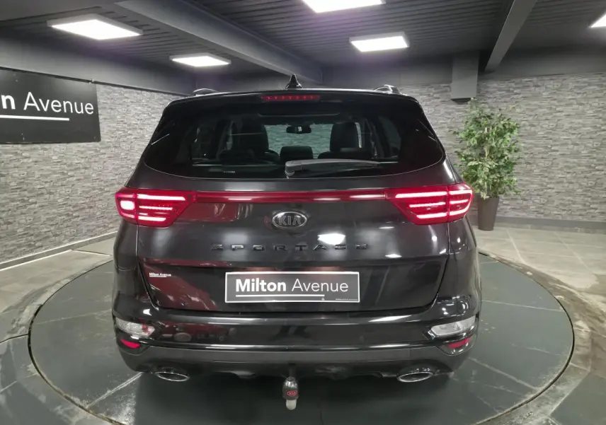 Vue arrière d'un KIA Sportage noir 2021 avec feux LED allumés et double sortie d'échappement chromée.