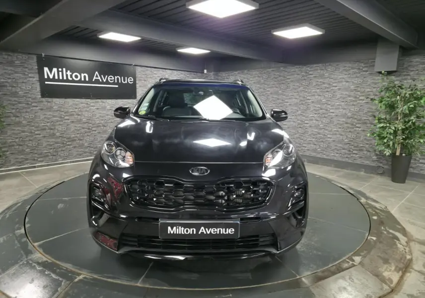 Vue frontale d'un KIA Sportage noir Black Edition 2021 avec calandre noire laquée dans un showroom.