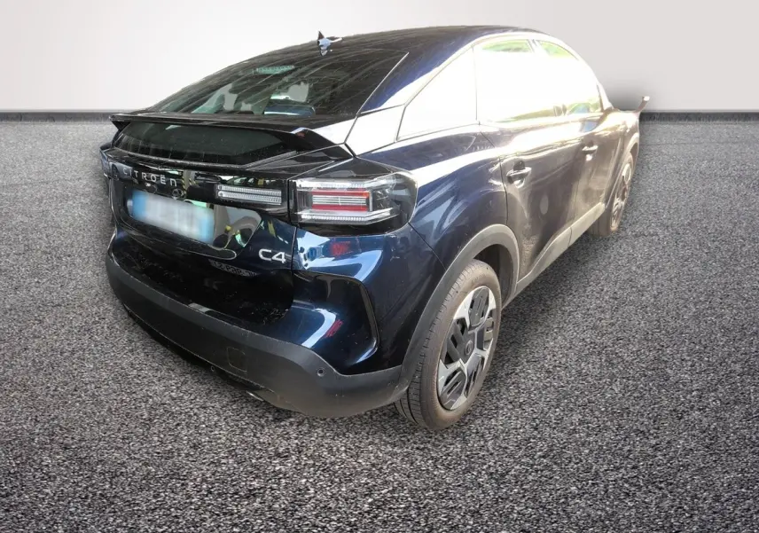 Vue 3/4 arrière droite d'une Citroën C4 hybride bleu foncé avec feux arrière LED et spoiler de coffre.