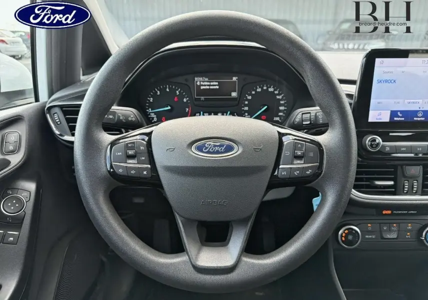 Vue intérieure centrée sur le volant noir de la Ford Fiesta 2020 avec tableau de bord et écran tactile visibles.