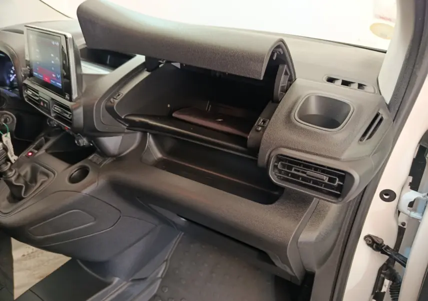 Intérieur du Citroën Berlingo 2022 blanc, vue côté passager sur la boîte à gants ouverte et tableau de bord noir.