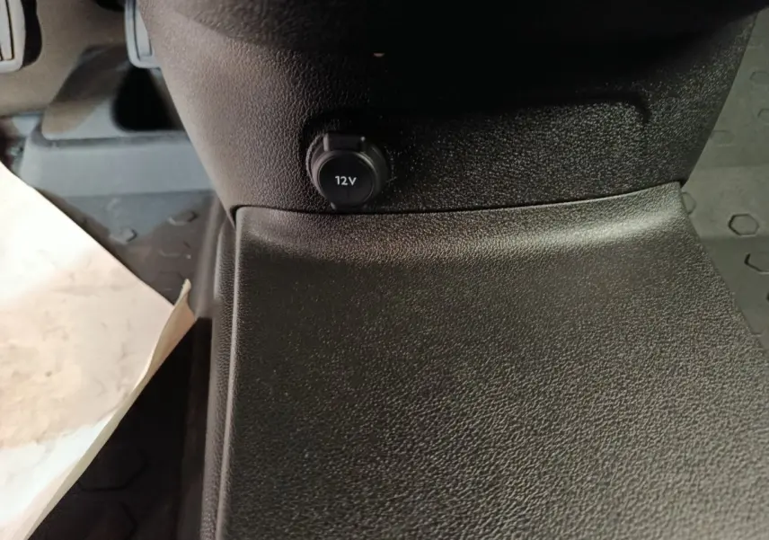 Prise 12V en gros plan sur la console centrale intérieure du Citroën Berlingo blanc, version 2022.