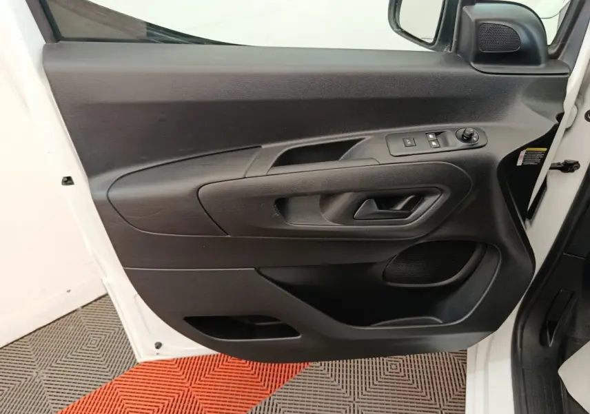 Vue rapprochée de la porte avant gauche noire intérieure du Citroën Berlingo blanc 2022 avec commandes électriques.