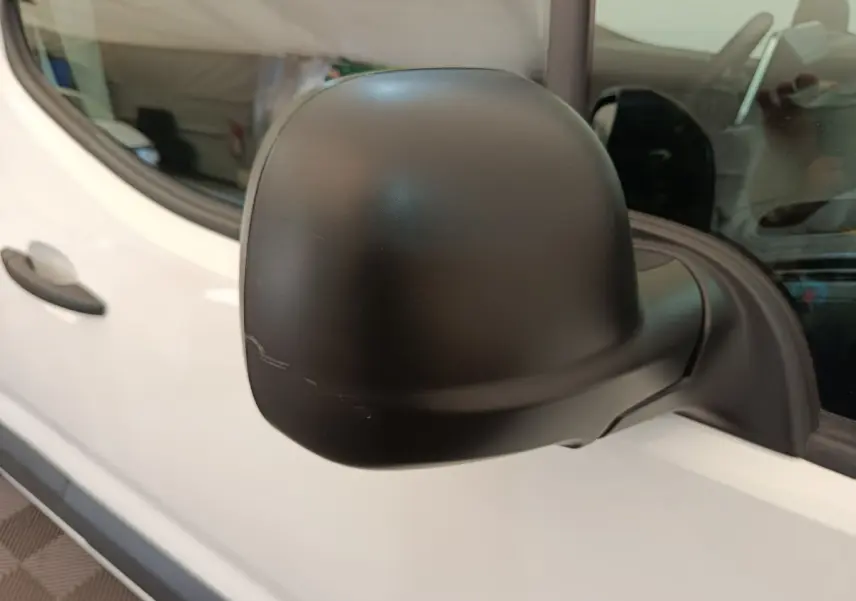 Rétroviseur noir en gros plan côté conducteur du Citroën Berlingo blanc 2022, vue latérale rapprochée.