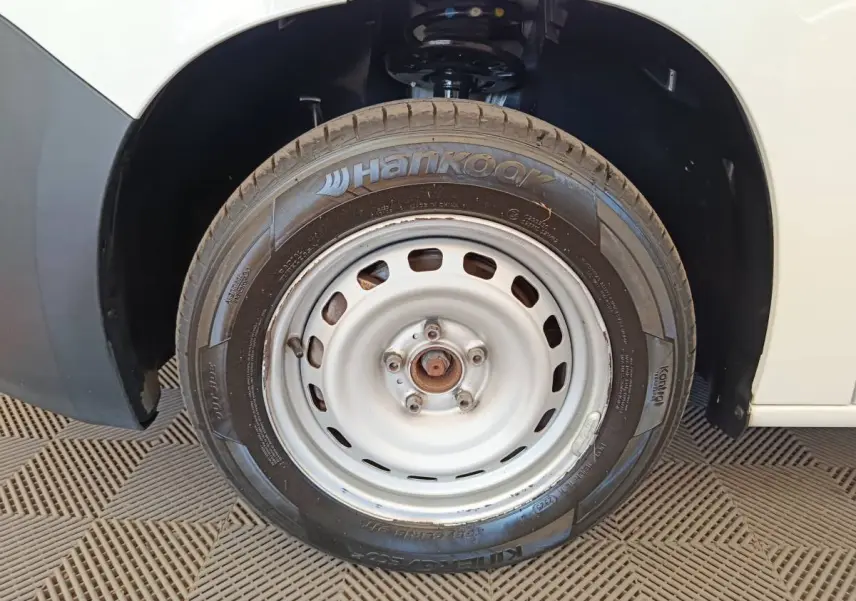 Gros plan sur la roue avant droite blanche d’un Citroën Berlingo blanc avec pneu Hankook visible.