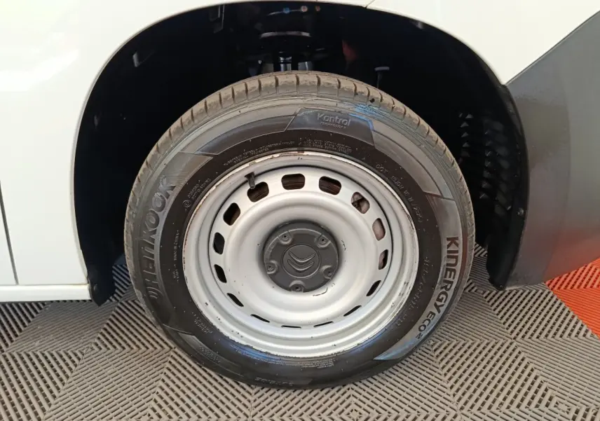 Gros plan sur la roue avant droite blanche en jante acier du Citroën Berlingo blanc, avec pneu Hankook visible.