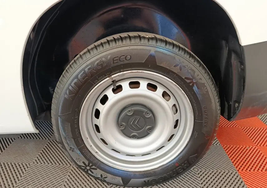 Gros plan sur la roue arrière droite blanche d’un Citroën Berlingo 2022 avec jante acier et pneu Kinergy Eco.