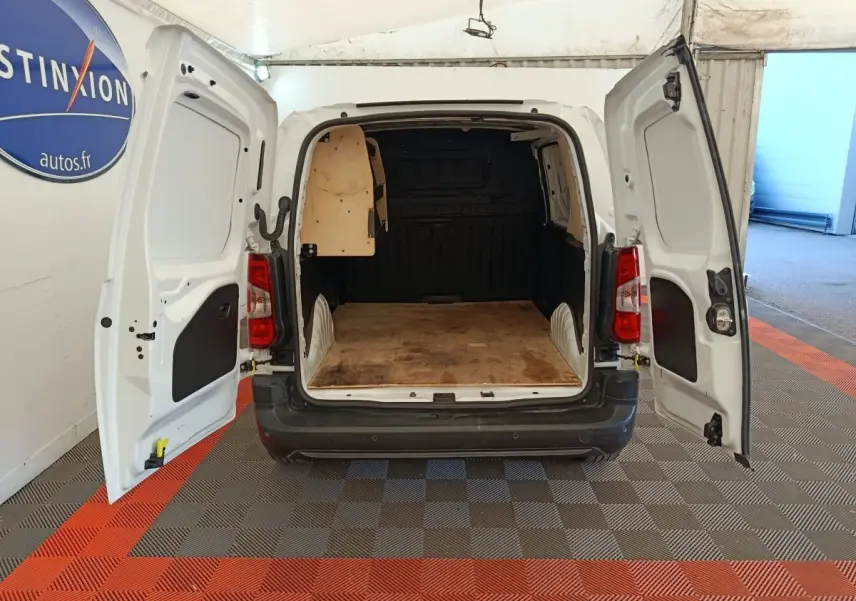 Vue arrière d’un Citroën Berlingo blanc 2022 avec portes arrière ouvertes montrant l’espace de chargement vide.