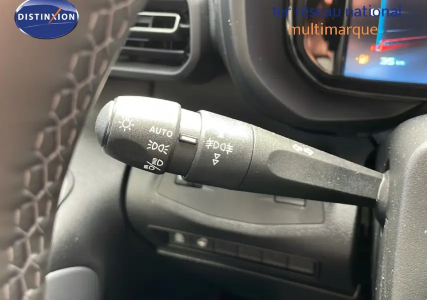 Gros plan sur la commande des feux à gauche du volant dans l’habitacle noir du Citroën Berlingo gris Artense 2026.