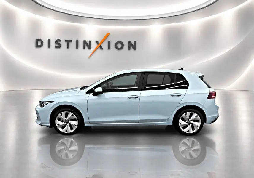 Profil droit d'une Volkswagen Golf 1.5 eTSI evo2 bleu glacier dans un showroom lumineux avec reflet au sol.
