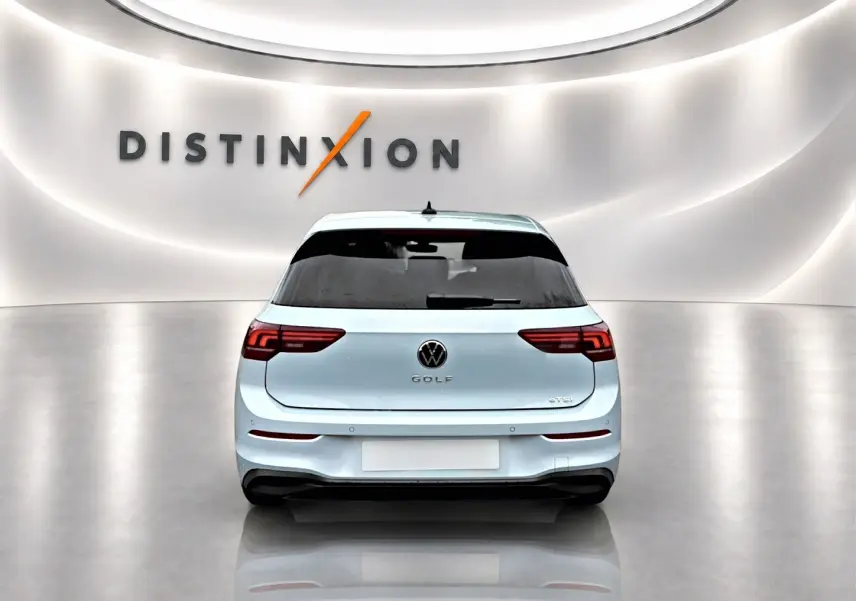 Vue arrière d'une Volkswagen Golf 1.5 etsi evo2 bleu glacier dans un showroom lumineux avec logo Distinxion en arrière-plan.