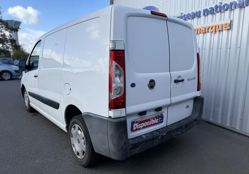 Vue 3/4 arrière droite d’un FIAT Scudo Fourgon blanc de 2015 avec portes arrière battantes et pare-chocs noir.