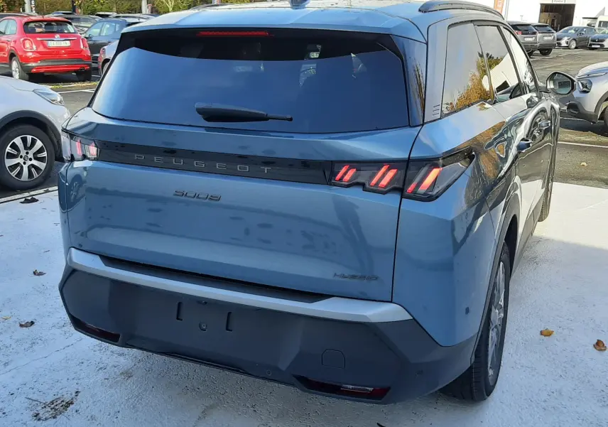 Vue 3/4 arrière droite d'un Peugeot 5008 bleu Ingaro avec feux arrière à griffes et vitre arrière teintée.