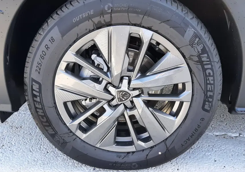 Gros plan sur la jante alliage moderne et le pneu Michelin du PEUGEOT 5008 bleu Ingaro, côté avant droit.