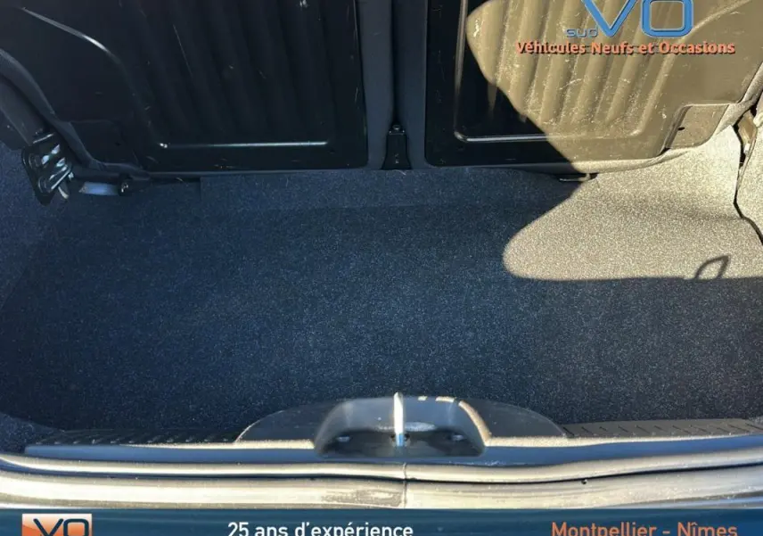 Coffre ouvert d'une FIAT 500C noire 2024, vue plongeante montrant l'espace de rangement et la roue de secours.