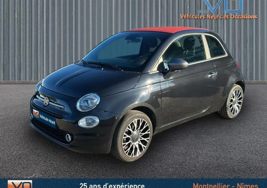 Vue 3/4 avant droite d'une FIAT 500C noire avec toit rouge et jantes alliage, modèle 2024 hybride essence.