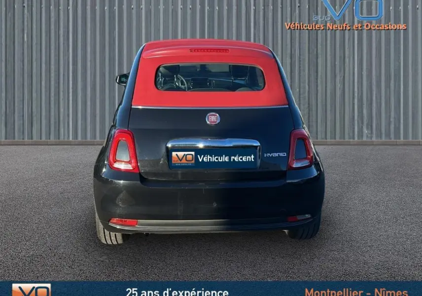 Vue arrière d'une FIAT 500C noire avec toit rouge, version hybride 2024, affichant le logo et l'inscription Hybrid.