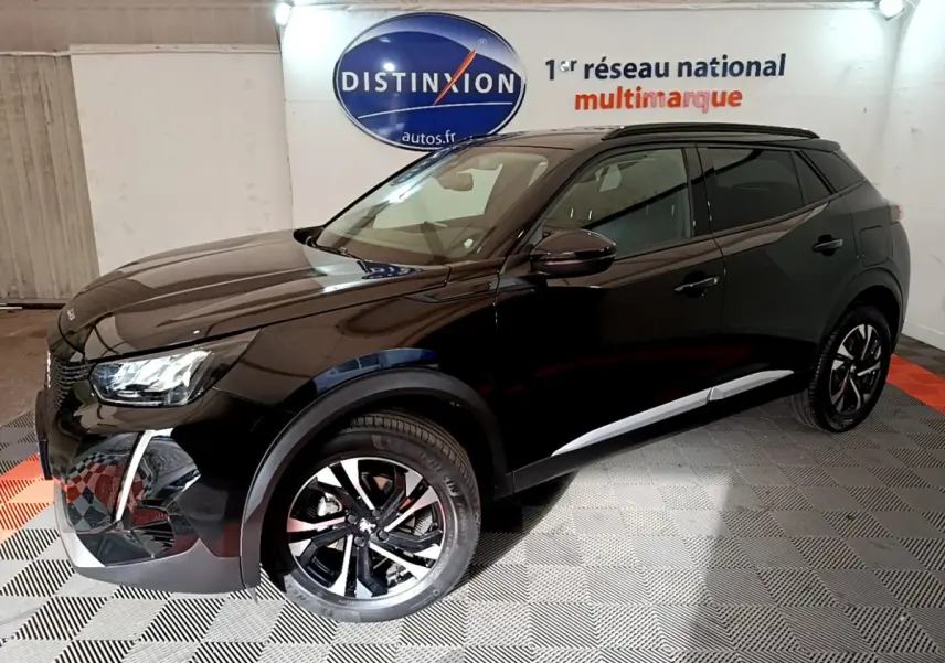 Peugeot 2008 PureTech 130 noir vue 3/4 avant droit, avec jantes alliage et toit noir brillant en intérieur showroom.