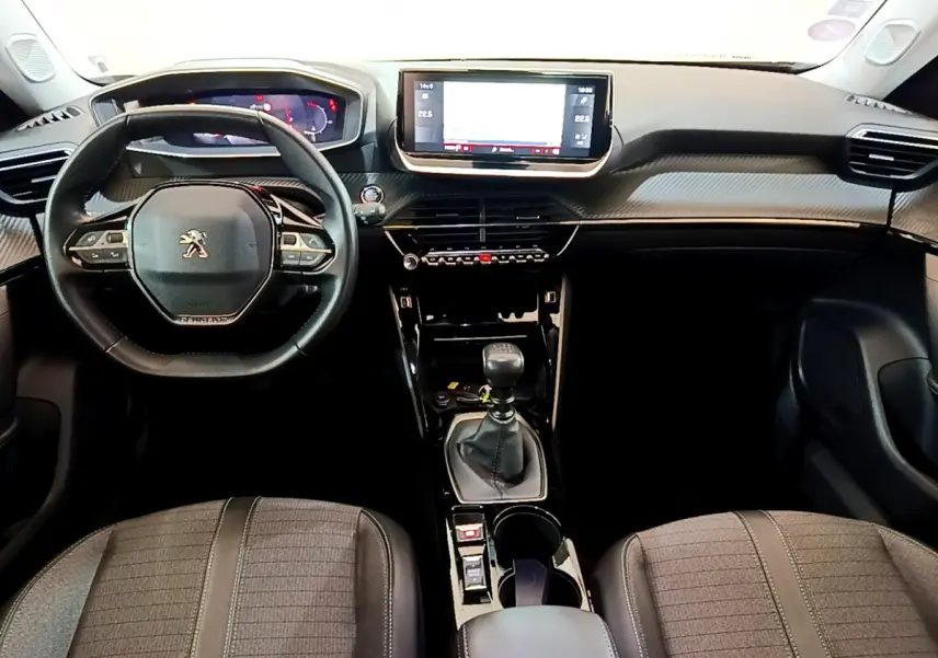 Intérieur noir du Peugeot 2008 PureTech 130, vue frontale sur le volant cuir, tableau de bord digital et écran tactile central.