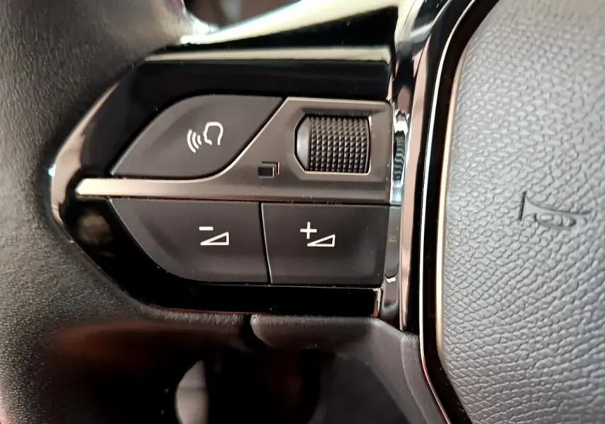 Gros plan sur les commandes gauche du volant cuir noir du Peugeot 2008 PureTech 130 S&S Allure Business 2021.