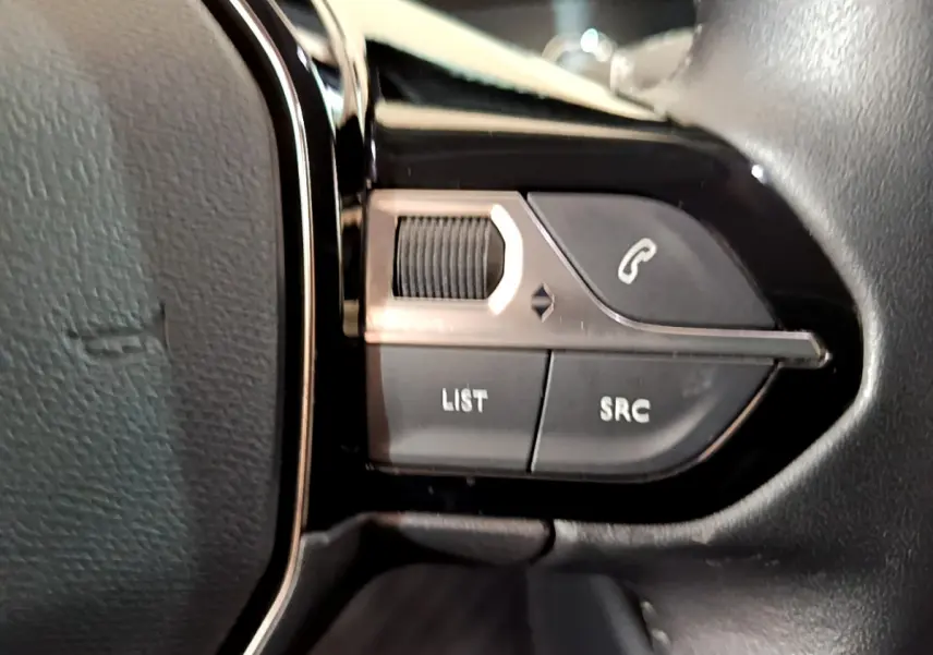 Gros plan sur les commandes du volant côté gauche du Peugeot 2008 noir PureTech 130 S&S Allure Business 2021.