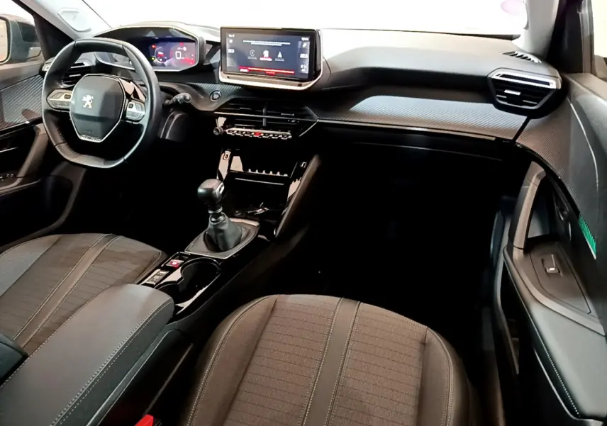 Intérieur noir du Peugeot 2008 PureTech 130, vue côté passager avec tableau de bord et écran tactile central.