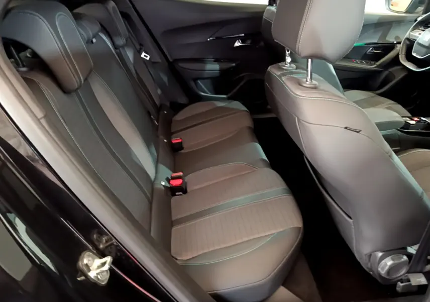 Vue intérieure côté gauche montrant la banquette arrière en tissu et cuir gris du Peugeot 2008 noir 2021 PureTech Allure Business