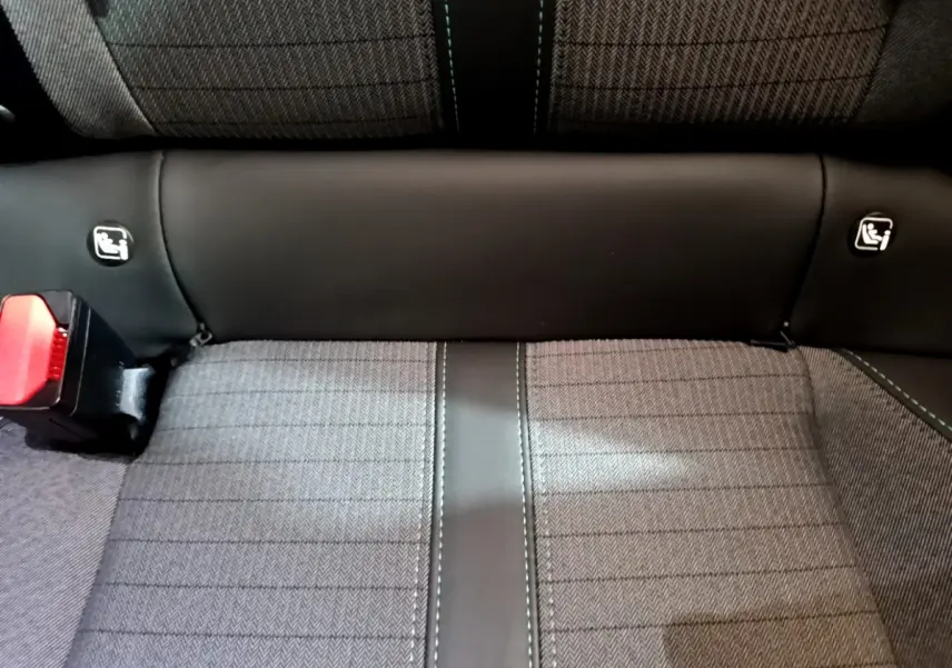 Gros plan sur la banquette arrière grise et noire du Peugeot 2008, avec fixations Isofix visibles et ceinture rouge.