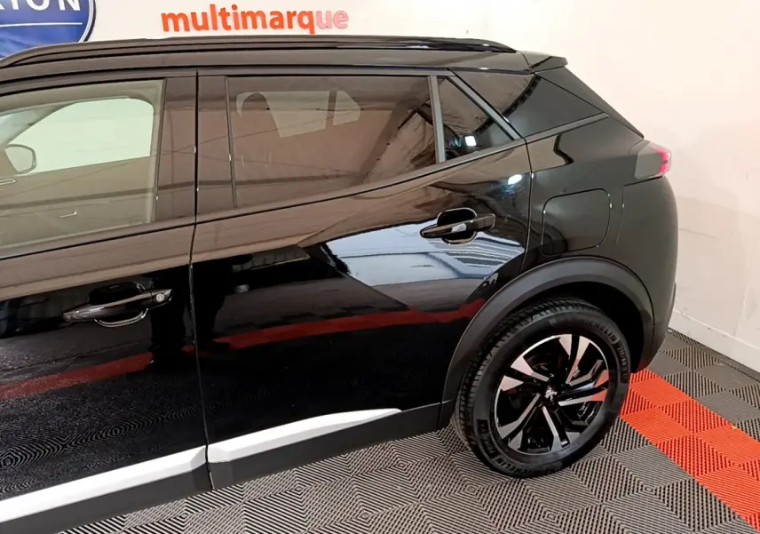 Profil côté droit du Peugeot 2008 noir 2021, mettant en valeur les jantes alliage et les lignes modernes du SUV.