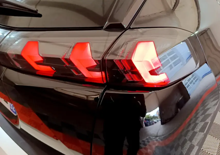 Gros plan sur les feux arrière rouges en forme de griffes du Peugeot 2008 noir, vue côté droit arrière.
