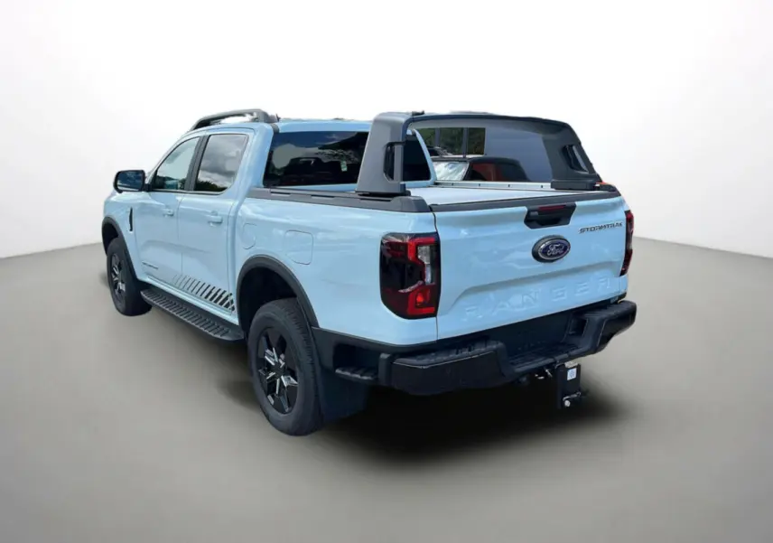 Vue 3/4 arrière droite d'un Ford Ranger Stormtrak gris zen avec arceau sport et attelage visible.