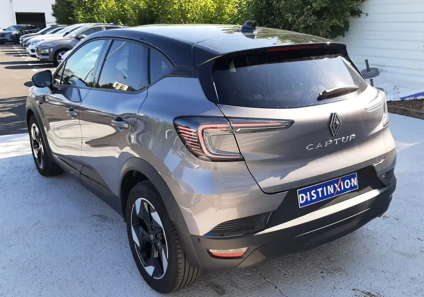 Vue 3/4 arrière droite d'un Renault Captur gris Cassiopée 2025 avec feux LED et toit noir contrasté.