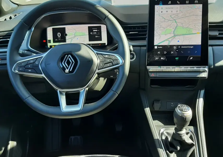 Vue intérieure du tableau de bord du Renault Captur II gris Cassiopée, avec volant multifonction, écran digital et boîte manuelle.