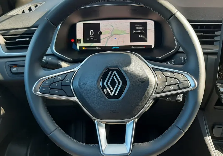 Vue rapprochée du volant noir du Renault Captur II avec tableau de bord numérique affichant la navigation.