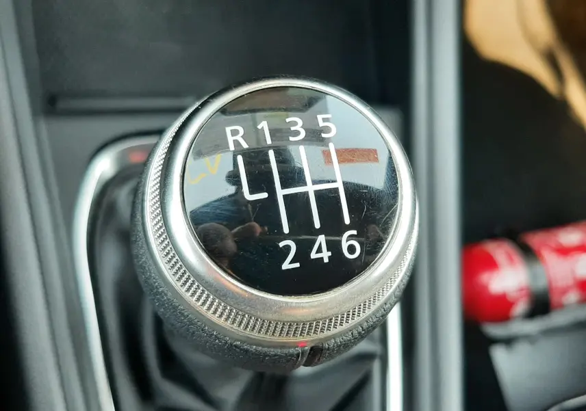 Gros plan sur le levier de vitesse manuel noir et chrome du Renault Captur gris Cassiopée, avec indication des six rapports.