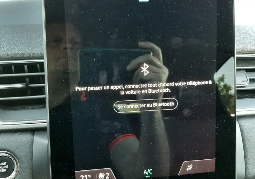 Écran tactile central du Renault Captur II gris cassiopée 2025 affichant l'interface Bluetooth et la climatisation.