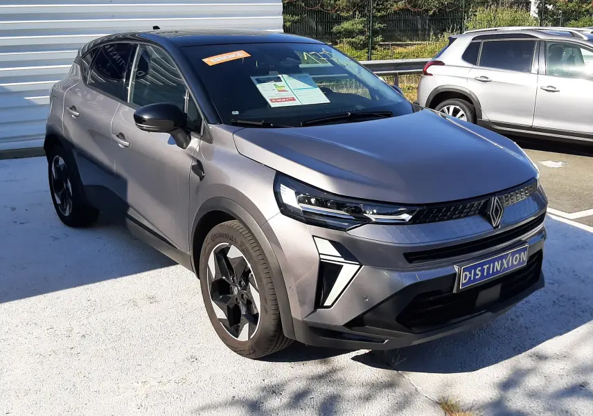 Renault Captur II gris cassiopée vu en 3/4 avant droit, avec jantes noires et toit noir contrasté.