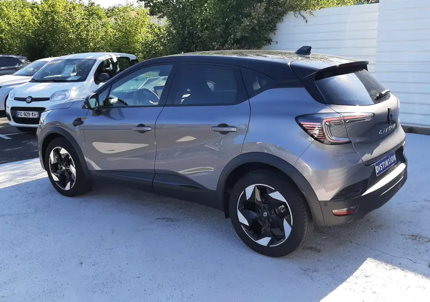 Renault Captur II gris Cassiopée en vue 3/4 arrière droit, toit noir et jantes bicolores distinctives.