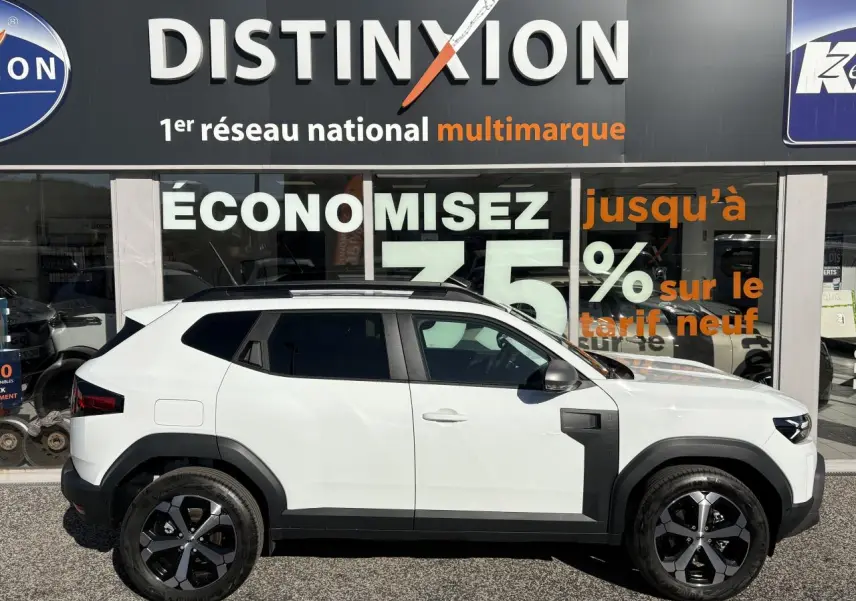 Profil droit du Dacia Duster 1.6 Hybrid blanc métallisé avec jantes alliage noires et barres de toit noires.