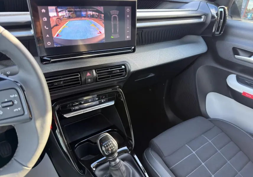 Vue intérieure côté passager de la Citroën C3 Turbo 100 BVM6 avec écran tactile et levier de vitesses manuel noir.