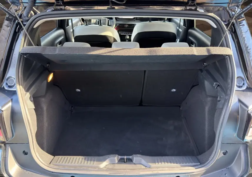 Vue arrière du coffre ouvert d'une Citroën C3 noire 2025, montrant l'espace de chargement et l'intérieur des sièges arrière.