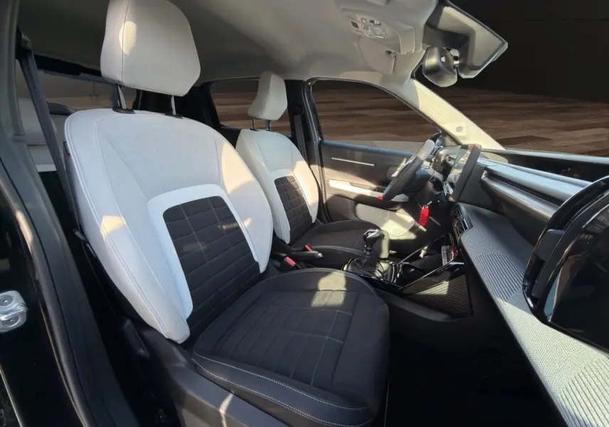 Vue intérieure côté conducteur de la Citroën C3 Turbo 100 BVM6 MAX 2025 noire, sièges bicolores noir et blanc, tableau de bord moderne.